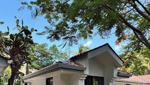 A white building with a tiled roof, a paved entrance, and a stone pathway. - Private 2 Bedroom Home | Pool | Near Beach (Coco)