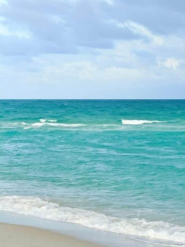 A beach with clear turquoise water and a cloudy sky. - Chardonnay Beach Escape, Naples, Florida (Naples)
