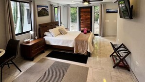 Une chambre d’hôtel moderne équipée d’un lit, d’un bureau, d’une chaise, d’une télévision et offrant une vue sur l’extérieur.