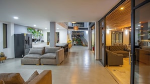 A spacious living area with a sofa, a dining table, and a kitchen in the background. - Modern country house in Sopetran, Antioquia. (Antioquia)