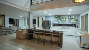 A modern kitchen with a central island, bar stools, and a refrigerator. - Modern country house in Sopetran, Antioquia. (Antioquia)
