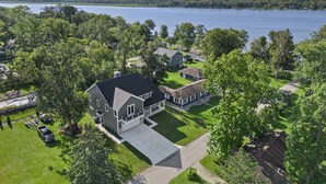 A large house with a spacious front yard and a lake view. - New Luxe Lake Home - Entertainment Rms - Lake view (Lake Geneva)