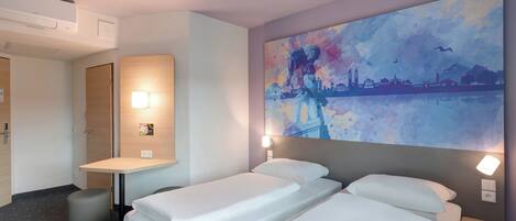 A hotel room with two beds, a desk, a chair, a wall-mounted air conditioner, and a large painting of a cityscape.