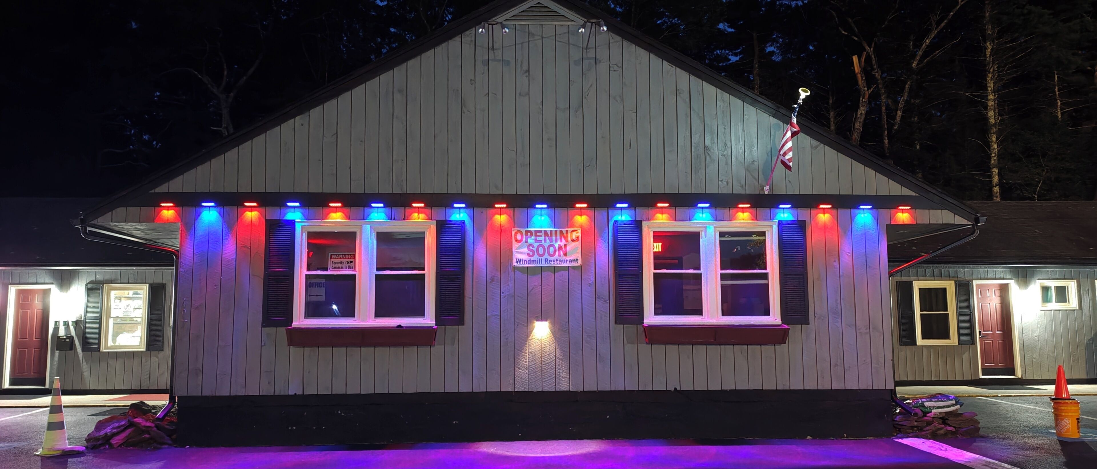 En byggnad med en skylt som visar texten ”Vindkraftsrestaurang”, flera fönster och en varningsskylt om säkerhet.