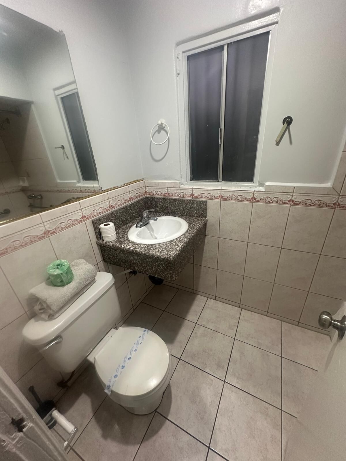 Un baño con inodoro, lavabo y espejo.