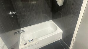 Ein modernes Badezimmer mit Badewanne, Duschbereich und Handtuchhalter.