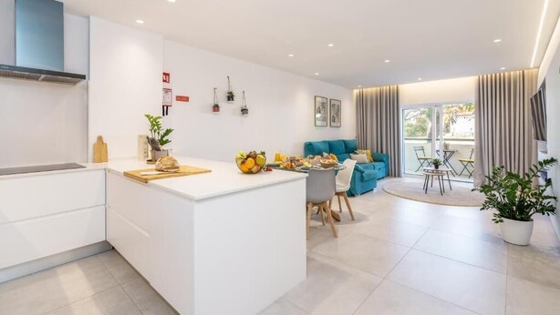 Ein modernes Apartment mit Küche, Essbereich und Wohnzimmer.