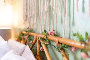 A bed with a headboard decorated with pink roses and greenery. - The Little Blue Seaside House (Scarborough)