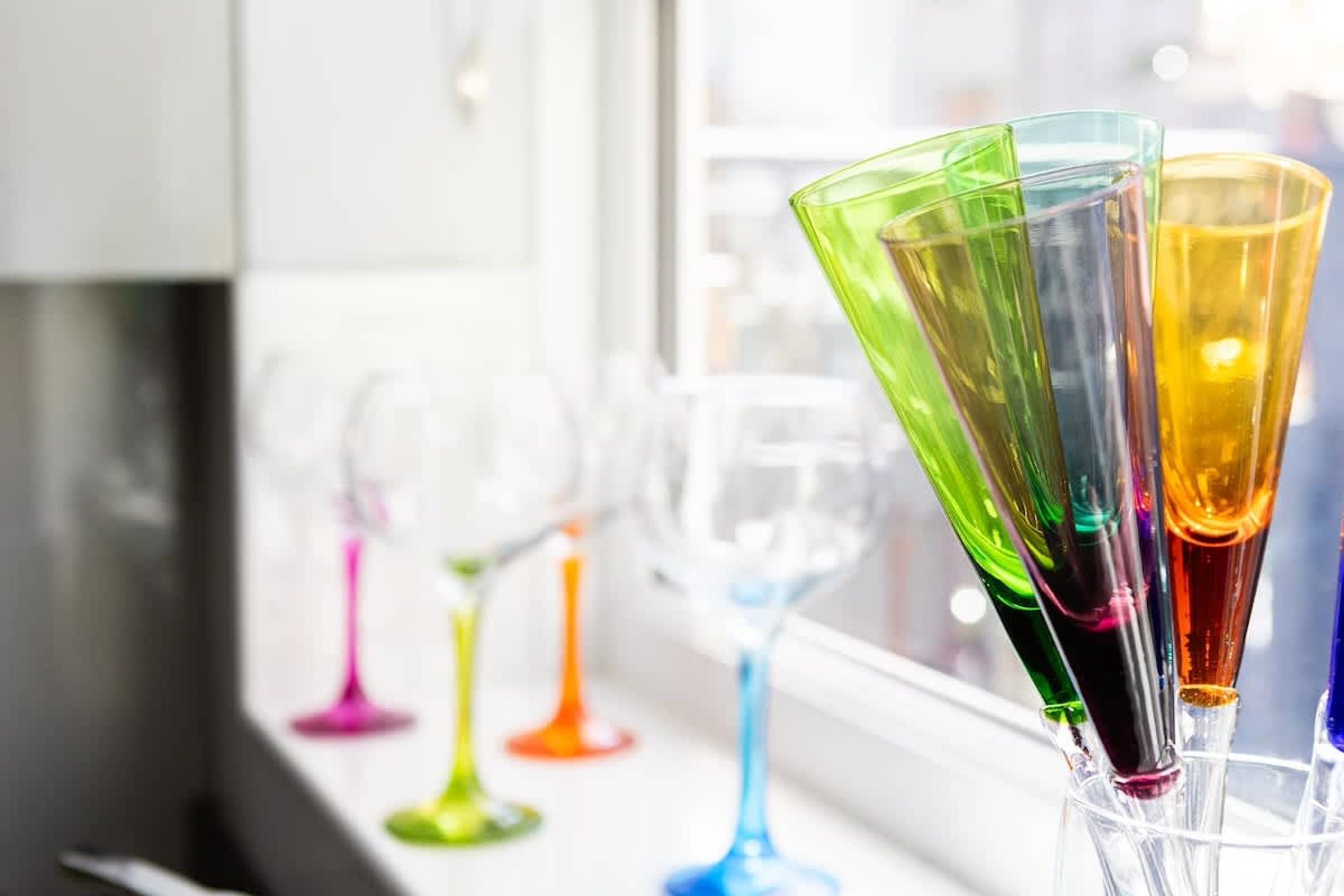 A row of colorful glassware on a kitchen counter.