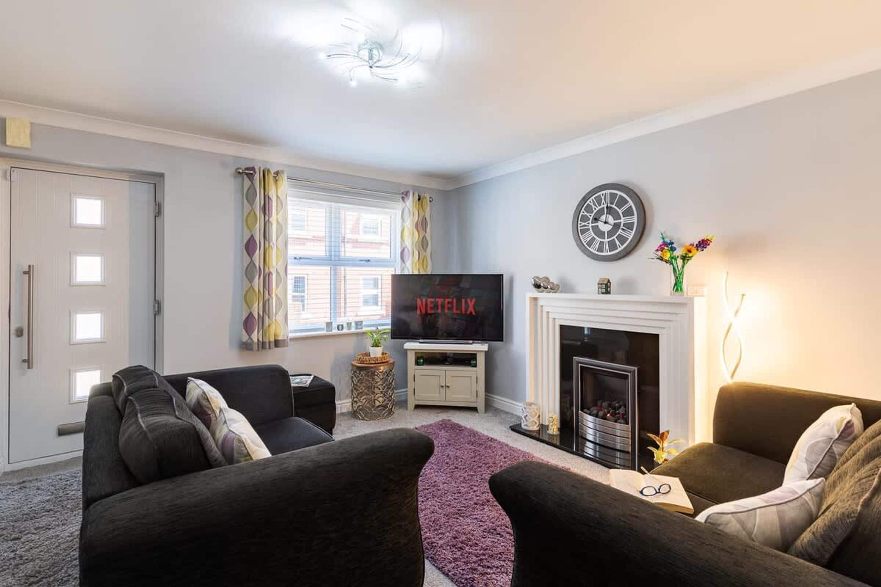 A living room with a fireplace, a TV, and two sofas.