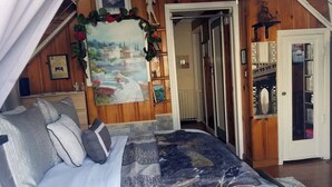 A bedroom with a bed, a painting, a bookshelf, and a door leading to another room. - Cozy 1-bedroom on the 2nd floor in Valley Stream, with a beautiful outdoor deck. (Valley Stream)