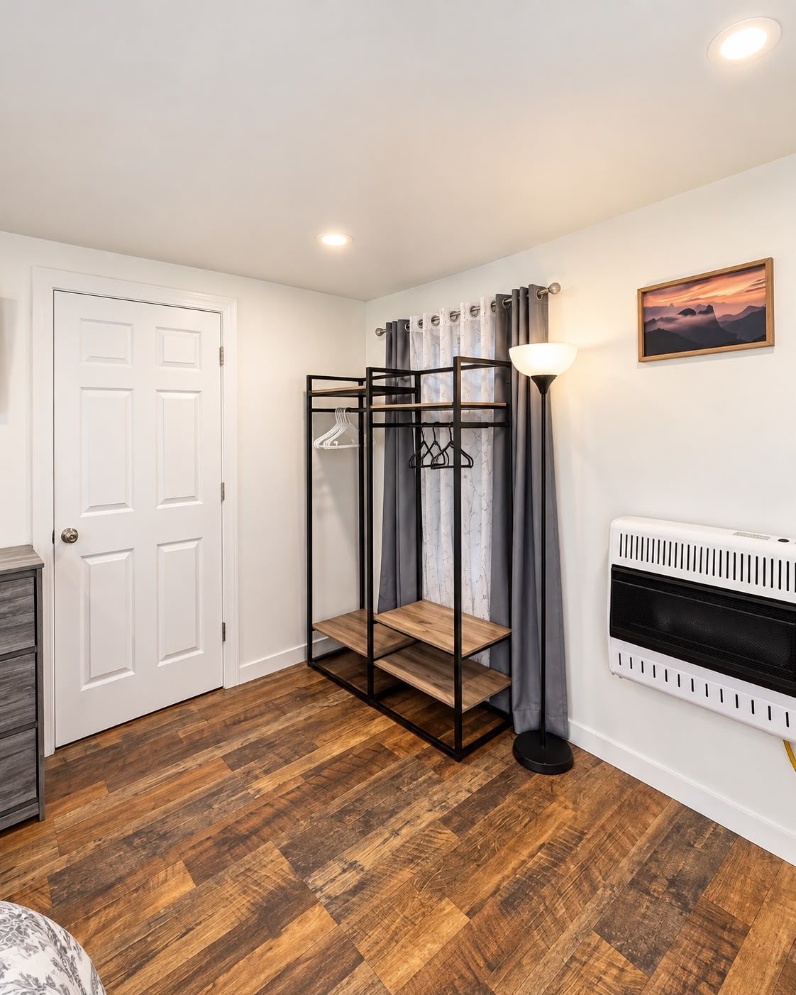 A room with a bunk bed, a radiator, a door, and a lamp.