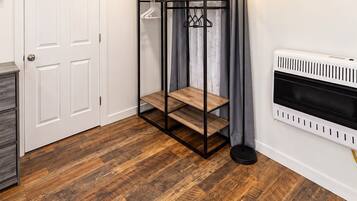 A room with a bunk bed, a radiator, a door, and a lamp.