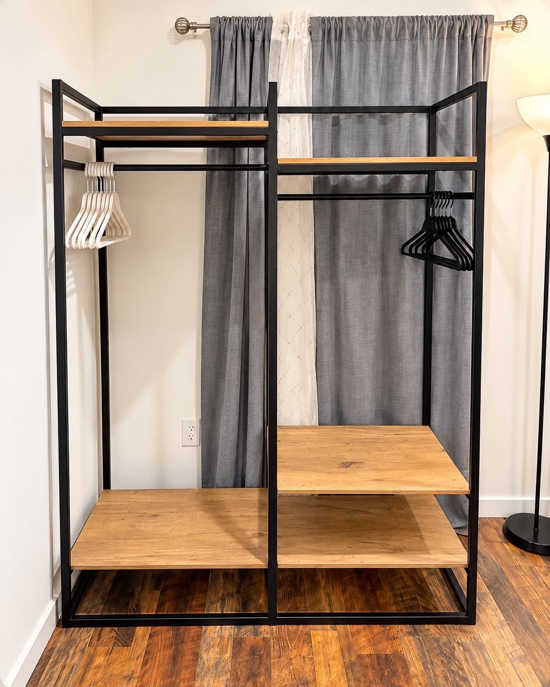 A bunk bed with a wooden frame and two shelves, a hanging light fixture, and a black floor lamp.
