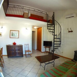 Apartamento Deluxe, vistas al jardín | Zona de estar | Una televisión