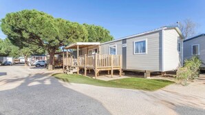 En campingvogn med terrasse og overdækket udendørsområde.