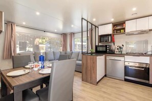 Una cocina moderna con comedor, que incluye microondas, horno y lavavajillas.