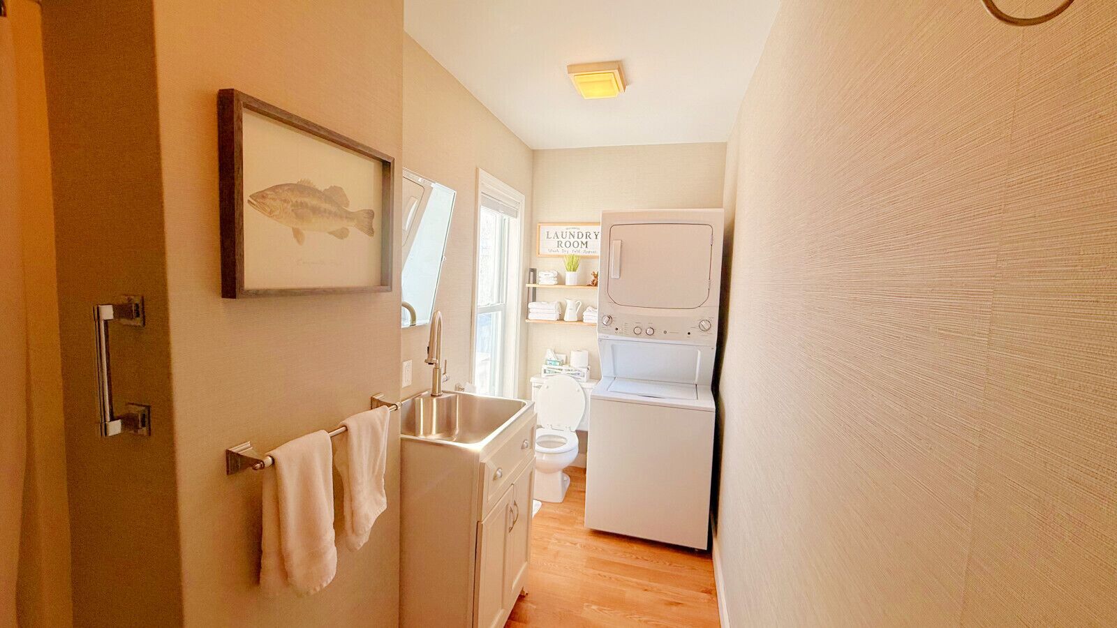 Een kleine keuken met een spoelbak, toilet en wasmachine.