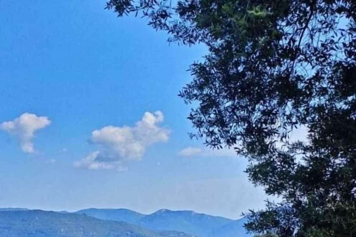 Un paisaje montañoso con una estructura de madera y una mesa, evocando un entorno rústico al aire libre.
