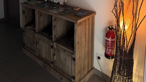 A wooden console table with a mirror, a fire extinguisher, and decorative branches. - Casa Stella  (Olmeto)
