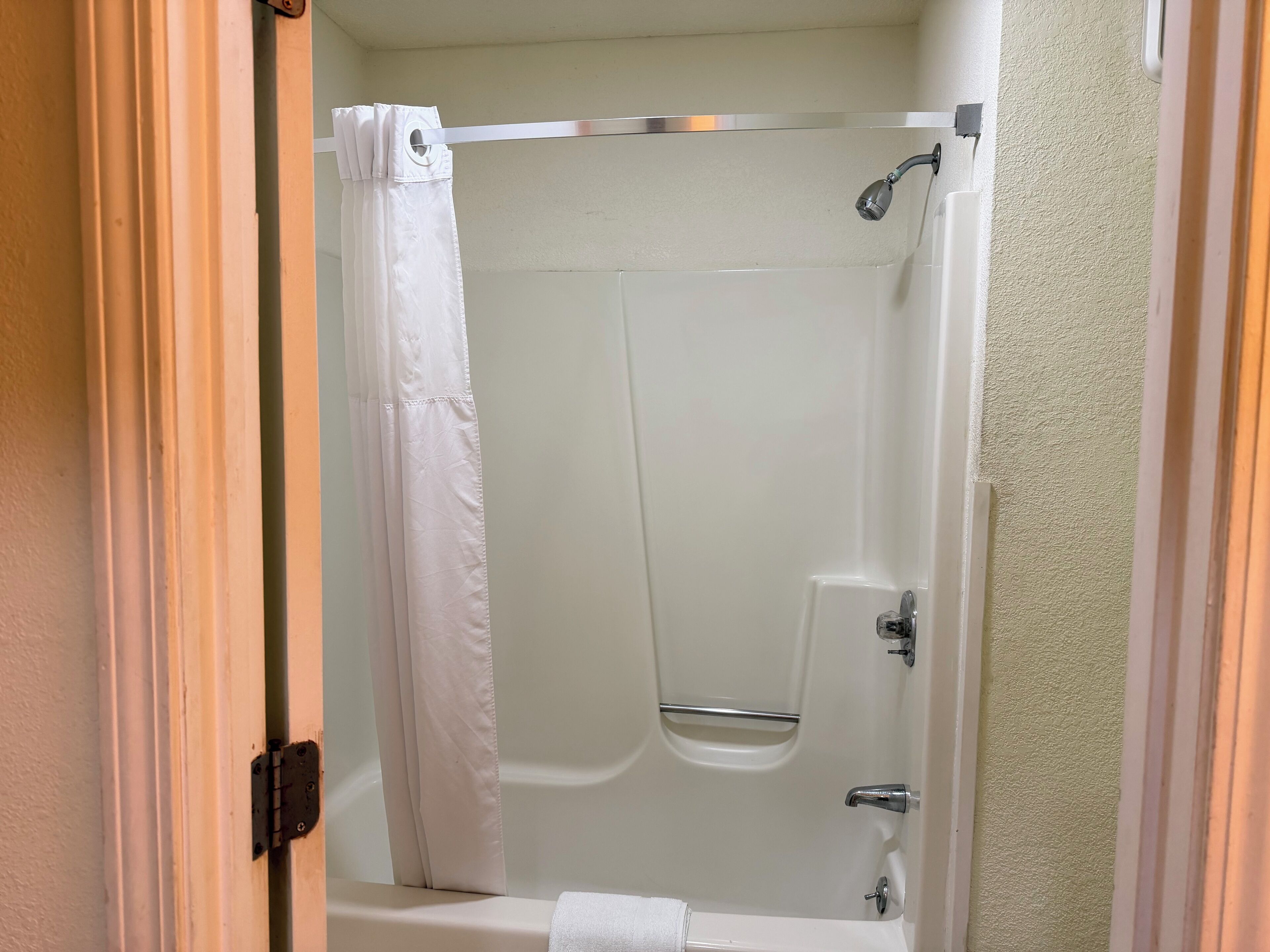 A bathroom with a shower, a bathtub, and a toilet.