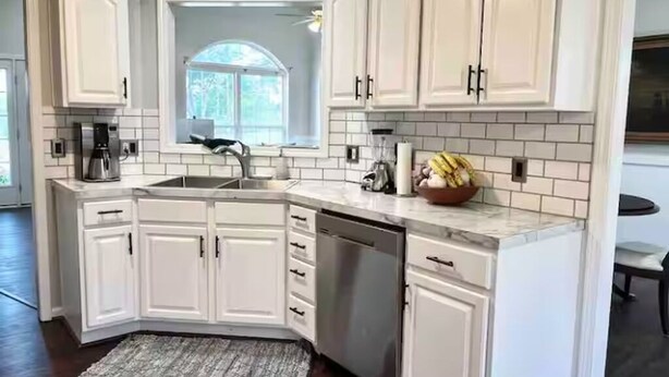 A kitchen with white cabinets, a built-in dishwasher, and a window with a view of greenery. - Very Convenient & Modern with Beautiful view (Country Club)
