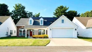 A two-story house with a garage, a front porch, and a well-maintained lawn. - Very Convenient & Modern with Beautiful view (Country Club)