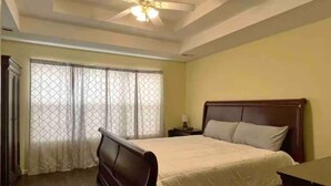 A bedroom with a bed, a nightstand, a ceiling fan, and a window with curtains. - Very Convenient & Modern with Beautiful view (Country Club)