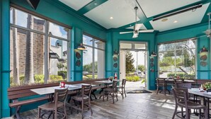 Ein Restaurant mit Türkiswänden, Holzböden und großen Fenstern.