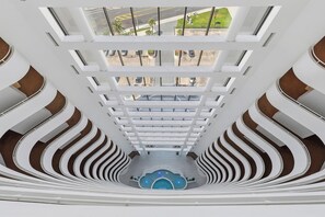 A multi-level atrium with a central pool and a view of the parking area outside. - 🌅Oceanfront | Incredible Ocean Views | Pet Friendly | Sherwin 901🌅 (Daytona Beach Shores)