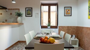 Un comedor con una mesa dispuesta para cuatro, una planta en maceta y obras de arte en las paredes.