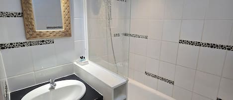 Een badkamer met een wit wastafel, een zwart aanrechtblad en een witte badkuip.