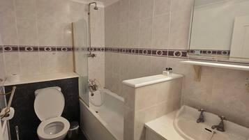 A bathroom with a toilet, bathtub, and sink.