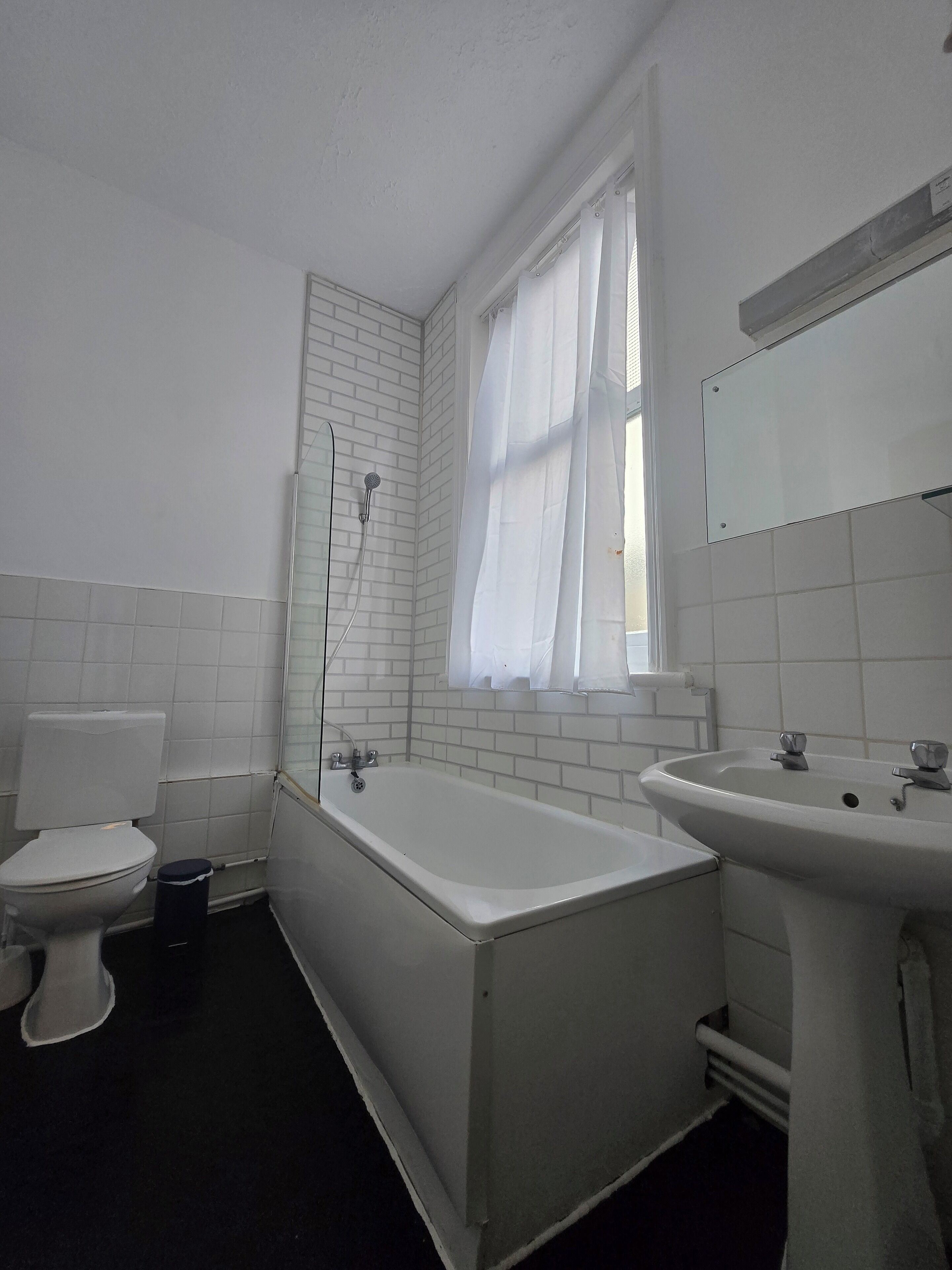 A bathroom with a toilet, bathtub, and sink.