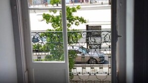 A view from a balcony with a metal railing, a street with cars, and buildings in the background. - Double Room 5 at Inn Chiado with Wi-Fi and Air Conditioning (Lisboa)