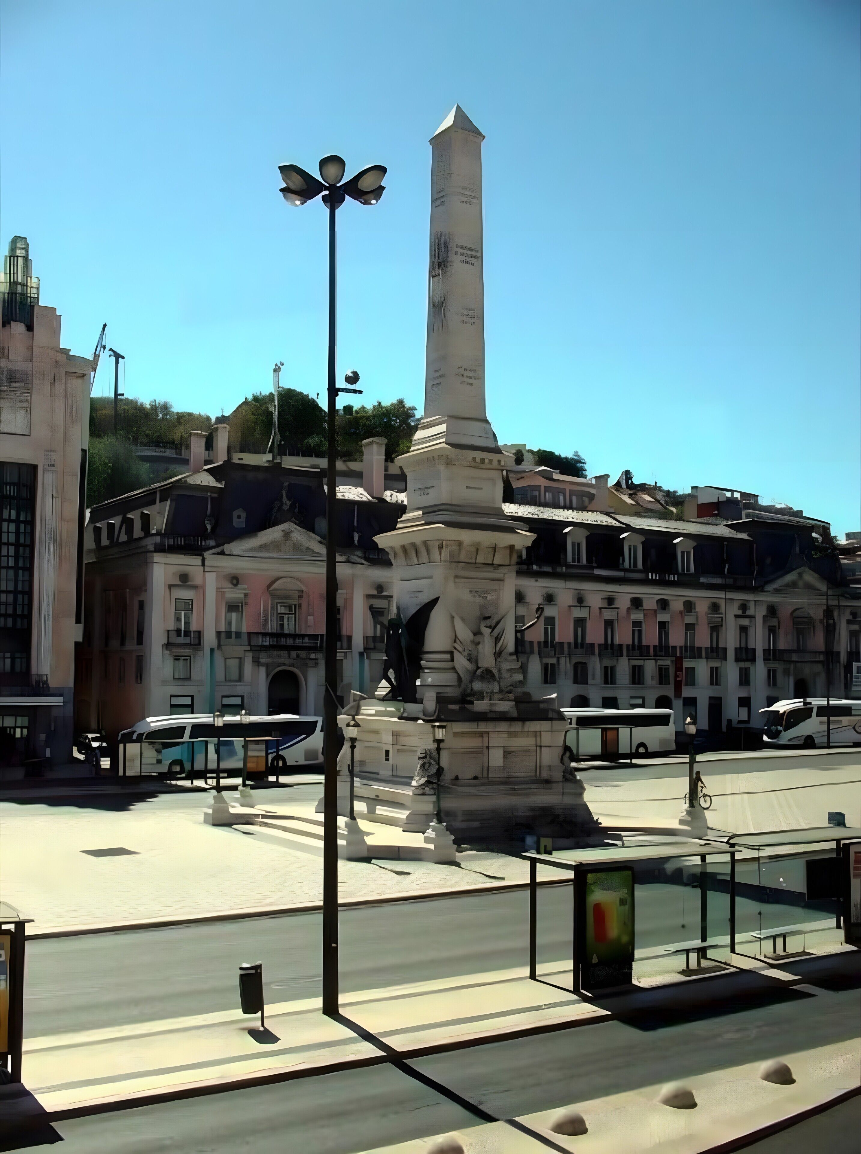 Un monumento con inscripciones, una farola y una fuente con estatuas.