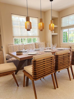 A dining area with a wooden table, multiple chairs, and hanging pendant lights. - Renovated house in top Cap Ferret location A0344 (Lège-Cap-Ferret)