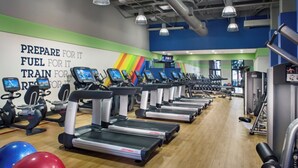 Ein Fitnessraum mit Laufbändern, Gymbällen und einer motivierenden Wand.