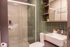 A modern bathroom with a glass shower enclosure, a white toilet, and a sink with a countertop. - Luxury Apartment in the Building. Gameleira Beach, Boa Viagem 1608 (Recife)