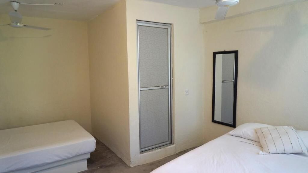 Un dormitorio con una cama individual, ventilador de techo y puerta corredera.