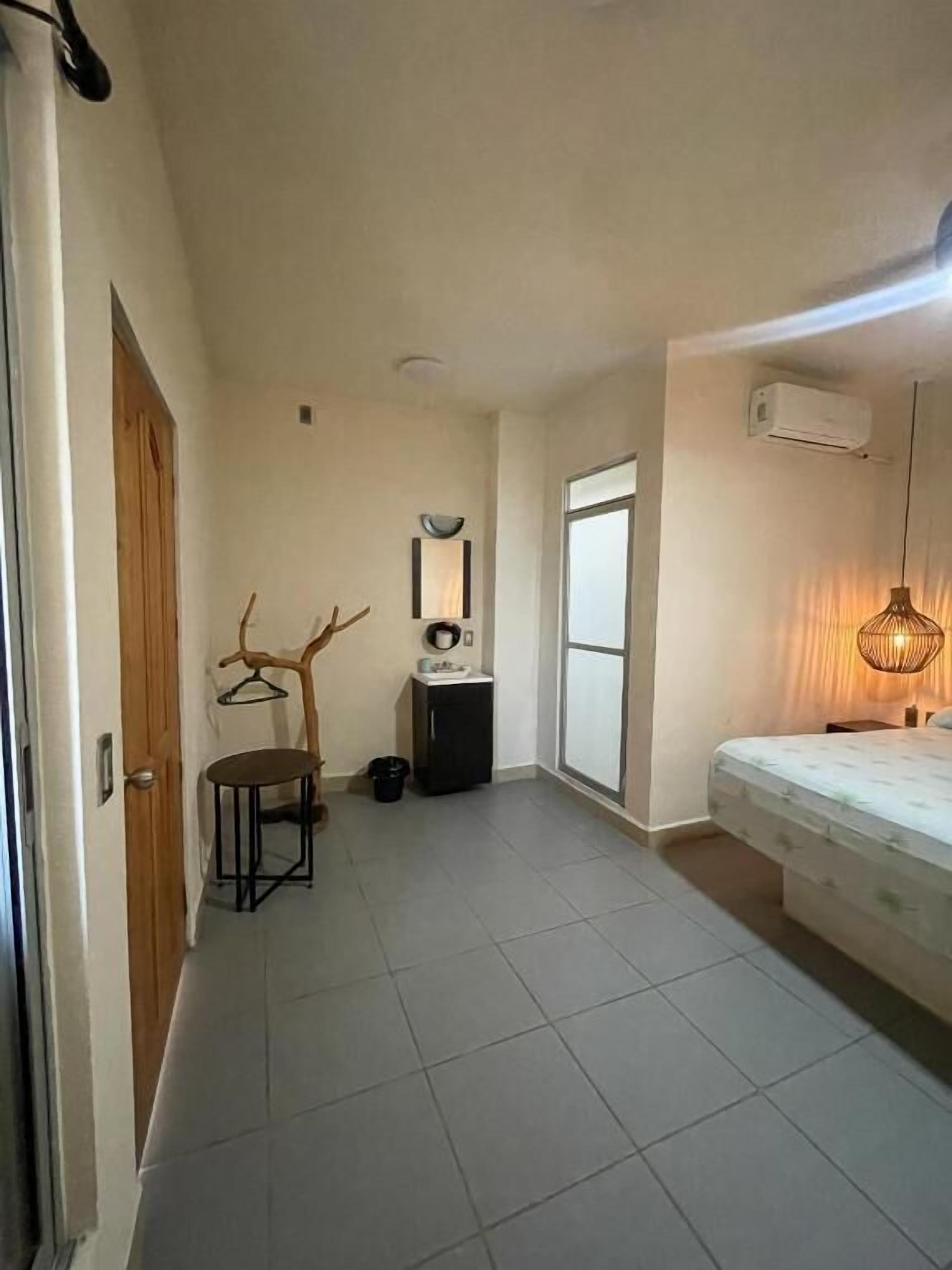 Ein Schlafzimmer mit Bett, Schreibtisch, Stuhl und einem kleinen Schrank.