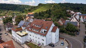 A multi-story building with a flat roof, solar panels, and a parking area. - Naturparkhotel & Landgasthof Stromberg (Sachsenheim)