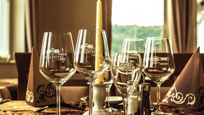 A table set for dining with wine glasses, a candle, and tableware. - Naturparkhotel & Landgasthof Stromberg (Sachsenheim)