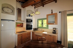 A kitchen with wooden cabinets, a white refrigerator, a microwave, an oven, and a coffee maker. - Gîte "Les Deux Cèdres" near Cassis, La Ciotat, Aubagne, shared pool, air conditioning (La Penne-sur-Huveaune)