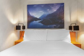Quarto com cama, mesa de cabeceira, pintura na parede e duas luminárias de parede.