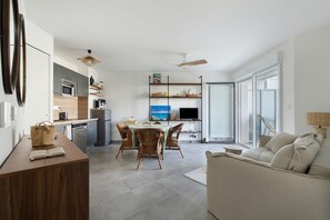 Et moderne køkken med spiseplads, en sofa og et fjernsyn.