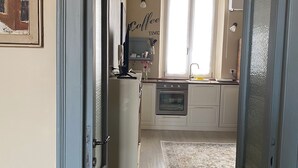 Una cocina con ventana, refrigerador y lavamanos.