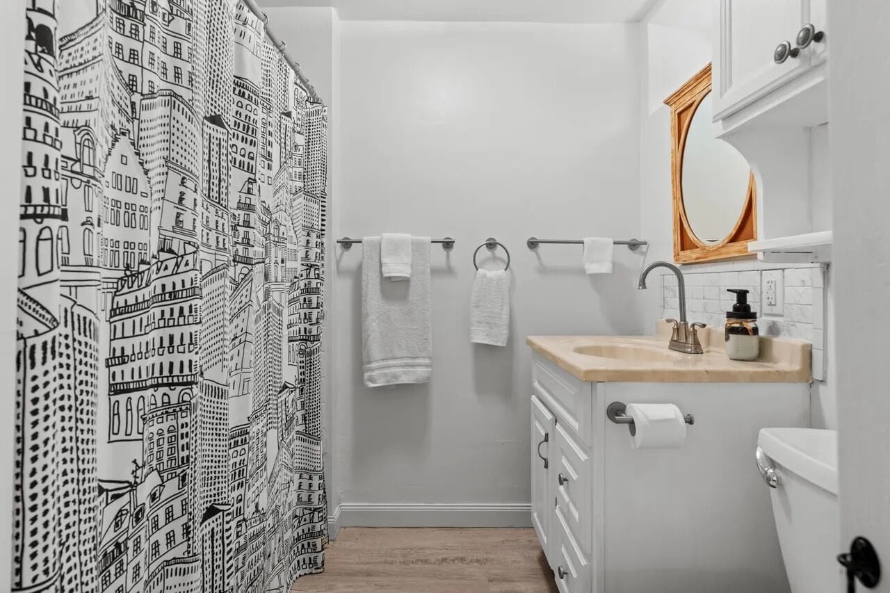 A bathroom with a white sink, a mirror, and a towel rack.