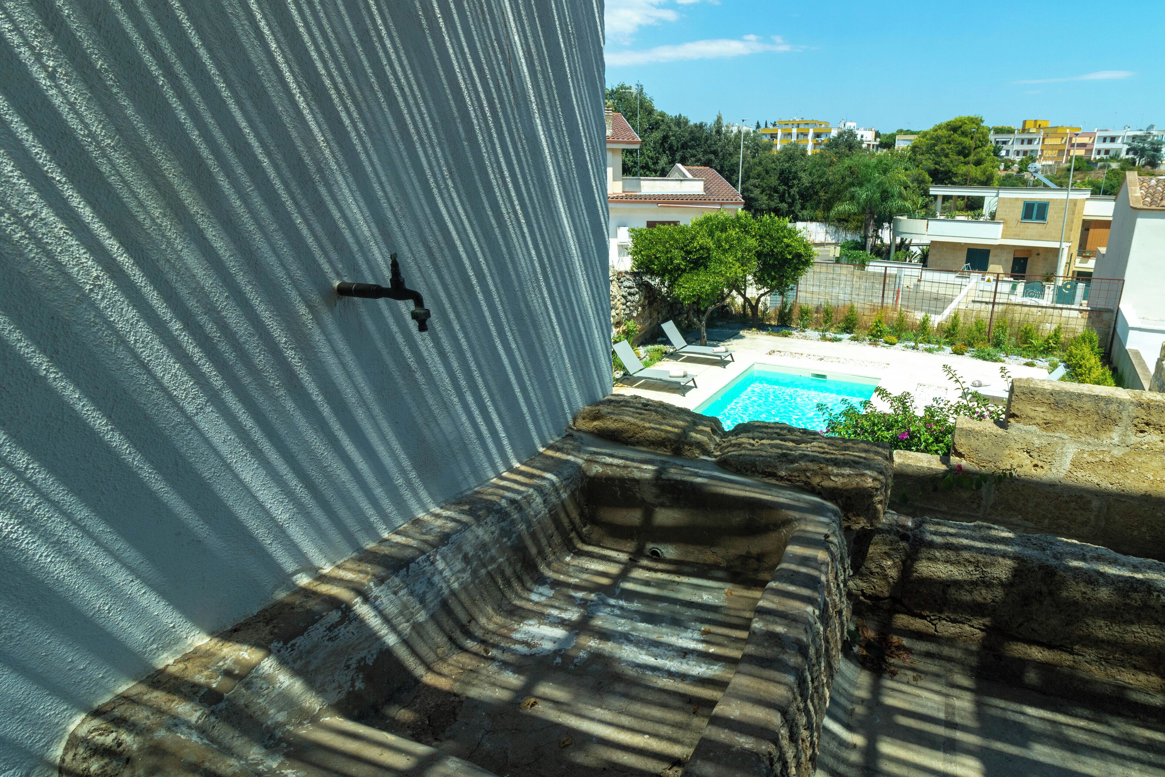 A rooftop pool with a view of surrounding buildings and greenery.