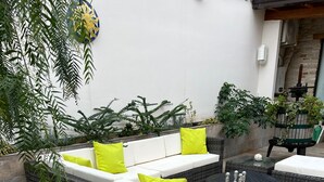 A patio area with a wicker sofa set, a round table, and a black tablecloth. - A beautiful guesthouse where you can relax and enjoy some quality time. (Lanzara)